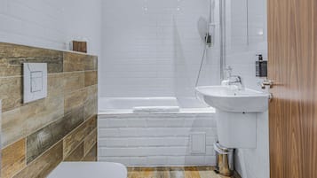 Deluxe studio | Badkamer | Een bad/douchecombinatie, gratis toiletartikelen, een haardroger