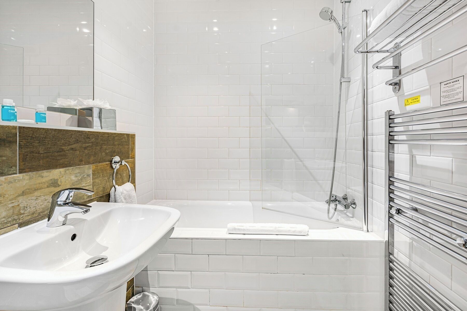 Une salle de bain moderne avec un lavabo blanc, une baignoire et une cabine de douche en verre.