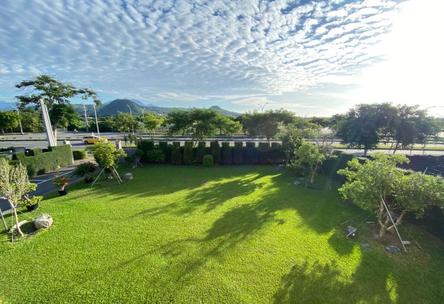 A well-maintained grassy area with trees and a clear sky.