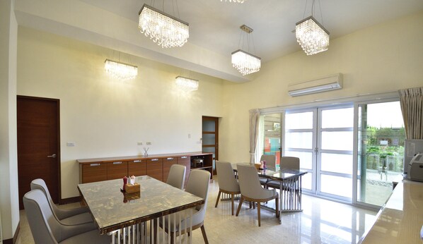 A modern dining area with a glass partition, a wooden cabinet, and a table with chairs. - Summer Moonlight Vacation House (Taitung)