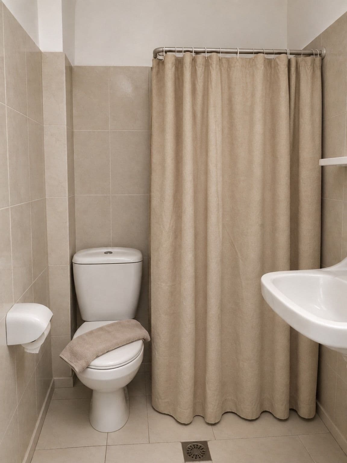 A bathroom with a toilet, a sink, and a shower curtain.