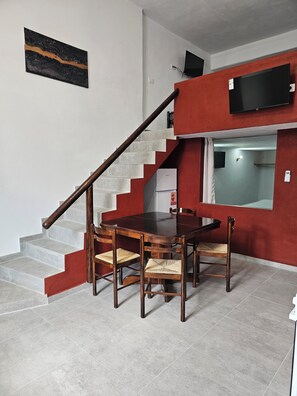 Una escalera con barandilla de madera que lleva a un comedor con mesa y sillas.