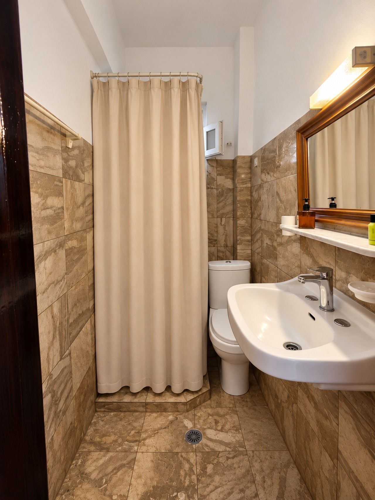 A bathroom with a shower curtain, toilet, sink, and mirror.