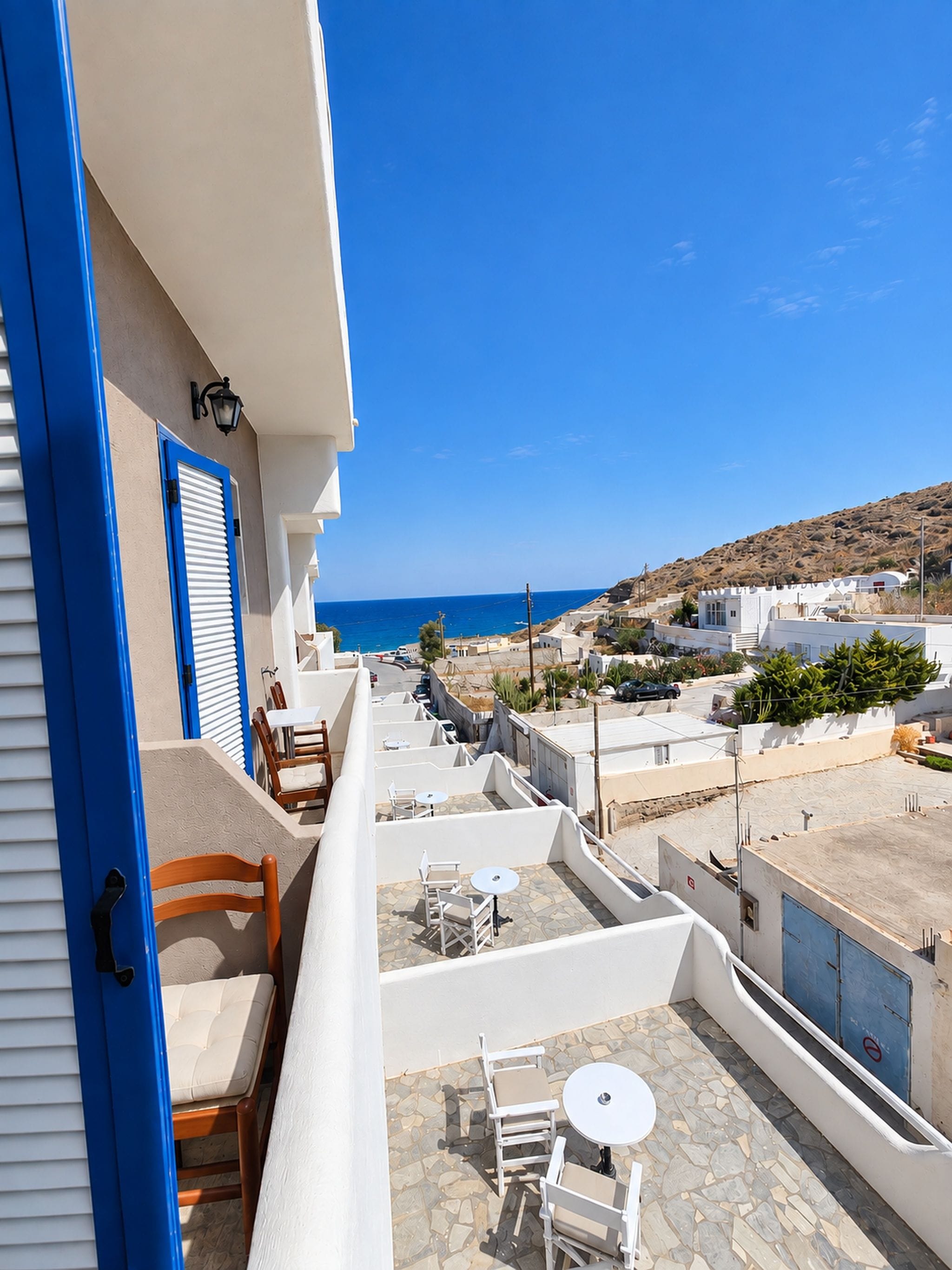 A terrace with outdoor seating and a view of the sea.