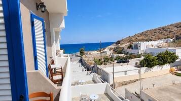 A terrace with outdoor seating and a view of the sea.