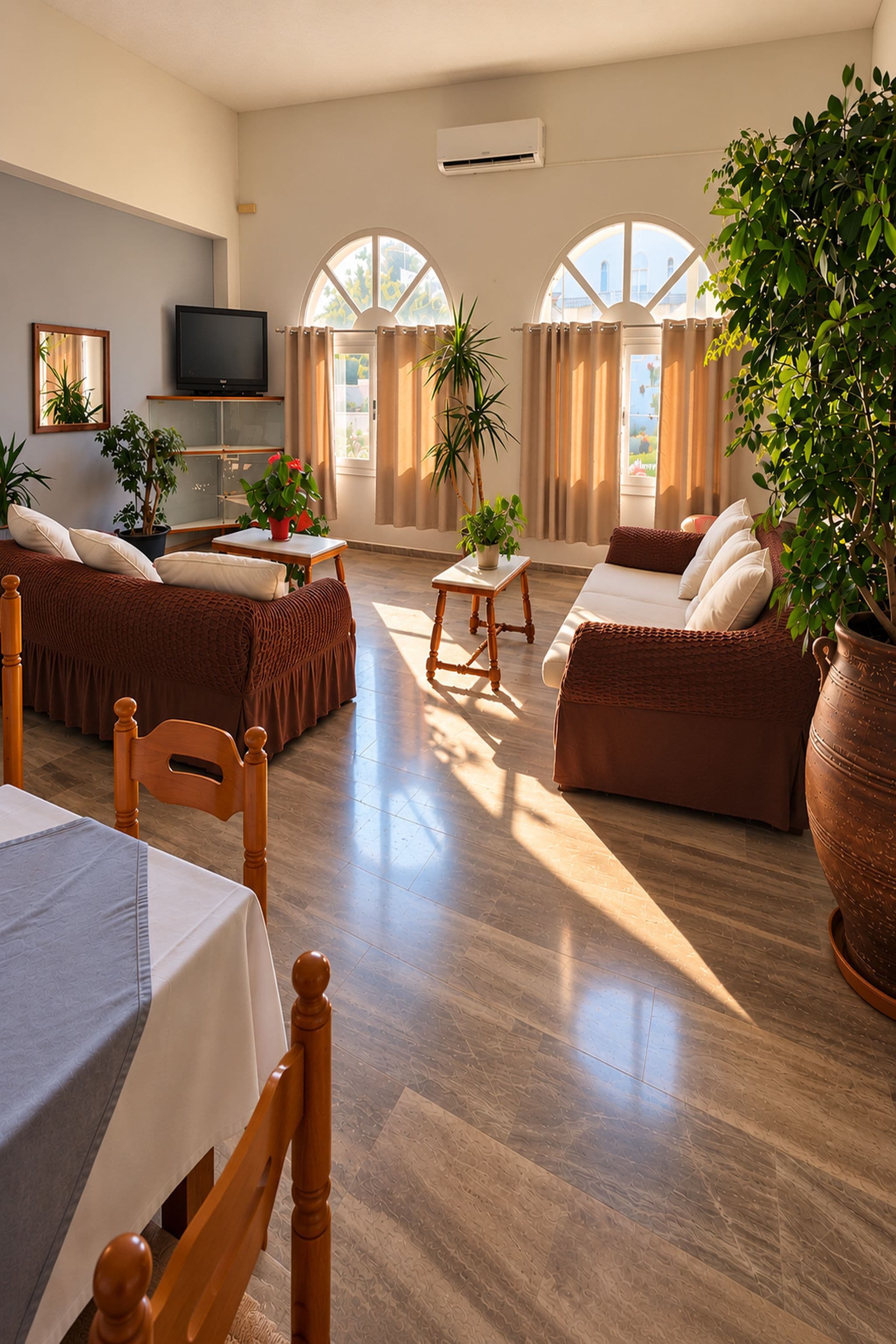 Un salón amplio con un ventanal grande, un televisor y una zona de comedor con mesa y sillas.