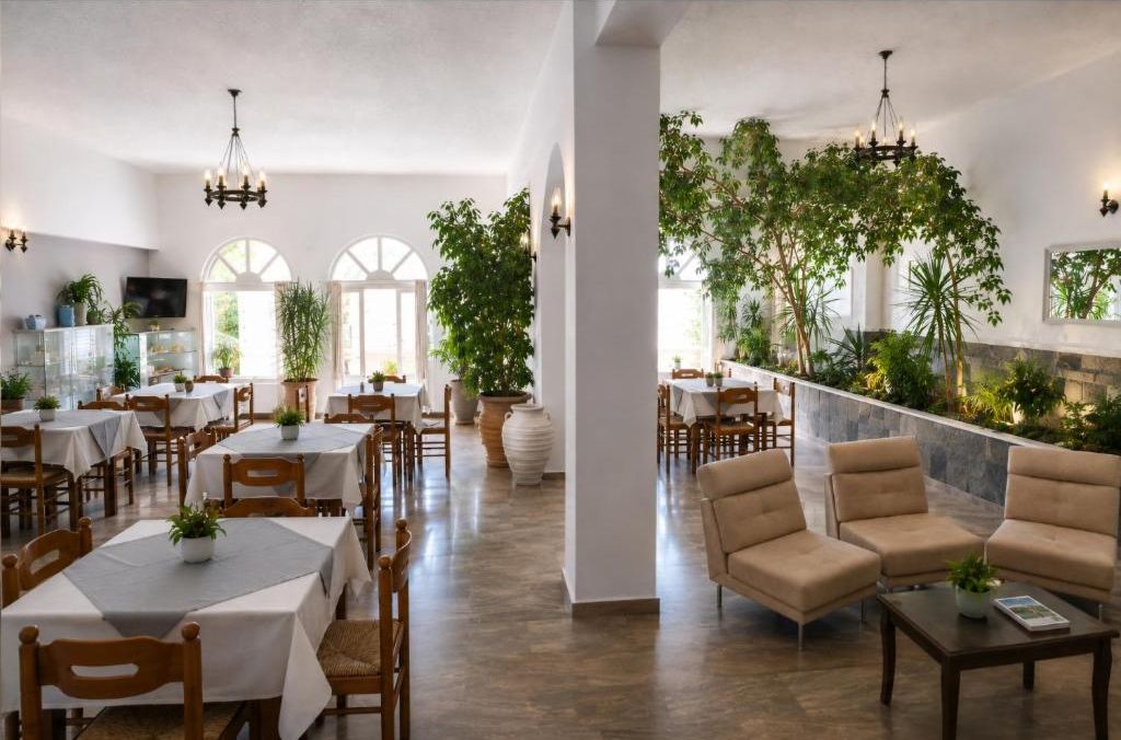 Ein Restaurant mit mehreren Tischen und Stühlen, einer Bar mit Theke sowie einer Sitzecke mit Sofas und einem Couchtisch.