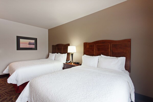 A hotel room with two beds, a nightstand with a lamp, and a framed picture on the wall. - Hampton Inn Seattle/Everett (Everett)