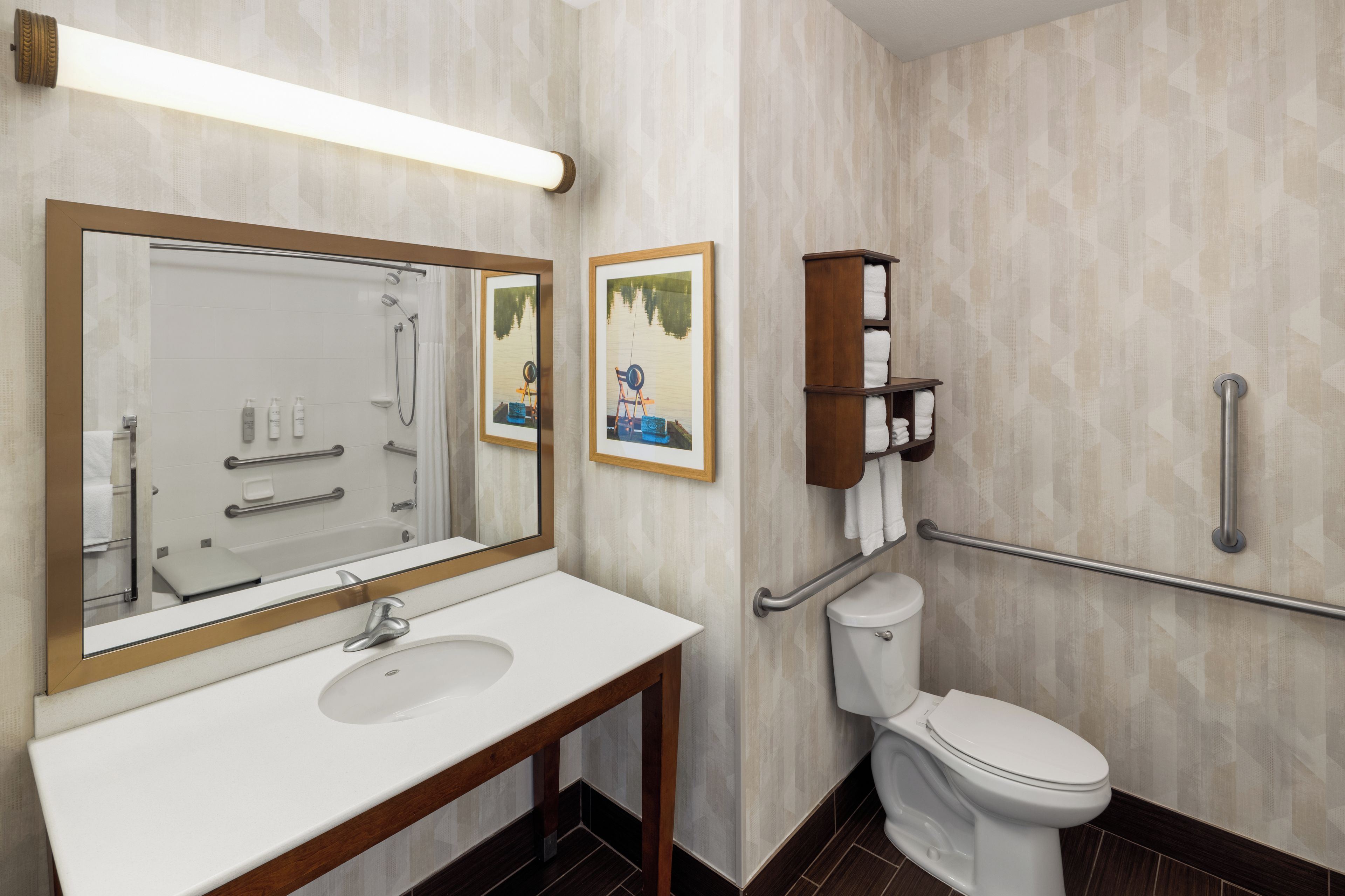 A modern bathroom with a large mirror, a sink, a toilet, and a shower area.