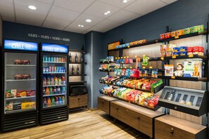 A snack and beverage section with refrigerated drinks, snacks, and a microwave. - Hampton Inn Seattle/Everett (Everett)
