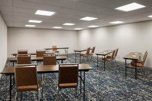 A conference room with tables and chairs, carpeted floor, and ceiling lights. - Hampton Inn Seattle/Everett (Everett)