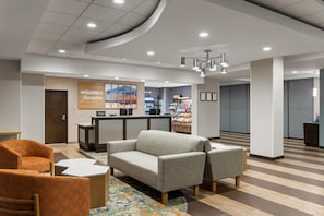 A hotel lobby with a reception desk, seating area, and a wall with a 'Welcome to Hampton' sign. - Hampton Inn Seattle/Everett (Everett)