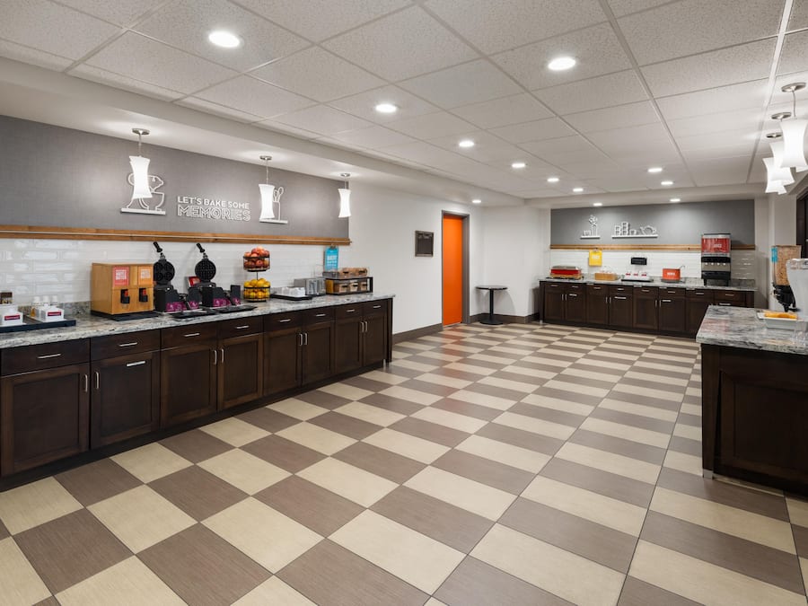 A modern kitchen with a checkered floor, a waffle station, and a juice bar.
