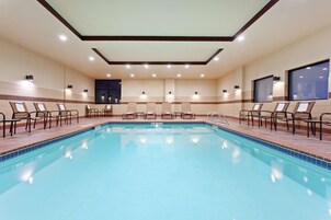 Una piscina techada, sillones reclinables de piscina