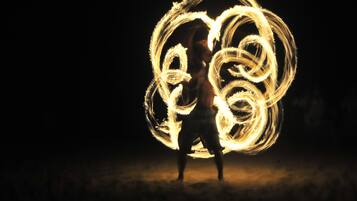 A person performing fire spinning with a large fire wheel.