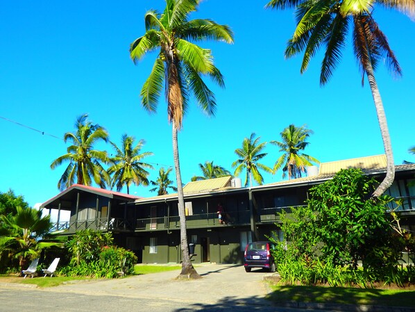 A two-story building with a flat roof and a balcony on the upper floor.