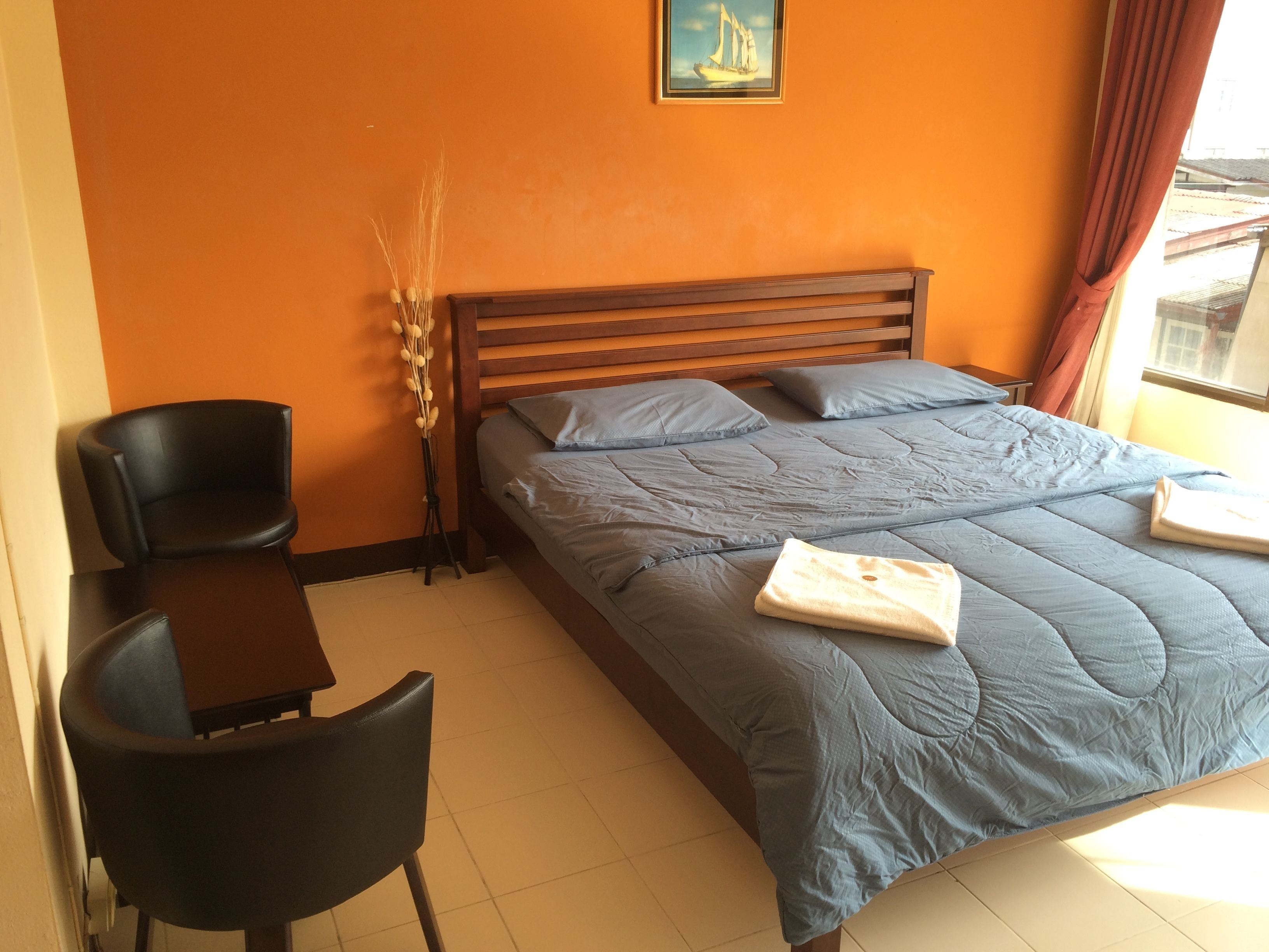 Quarto com cama, escrivaninha e cadeira.