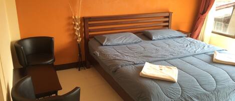 Quarto com cama, escrivaninha e cadeira.