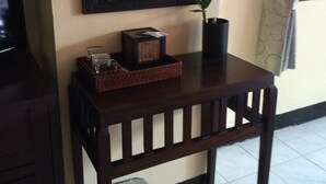 Una mesa de madera con un florero, un cuadro enmarcado y una cesta.