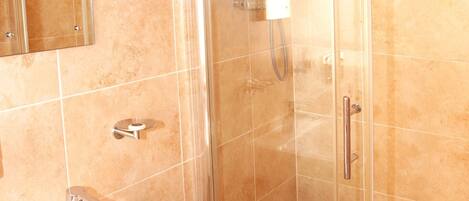 A bathroom with a glass-enclosed shower, a white sink, and a mirror above the sink.