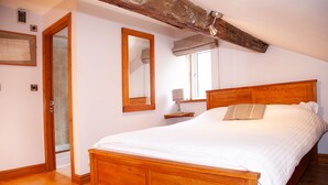 Un dormitorio con una cama de madera, un espejo grande y una ventana con vistas al exterior.