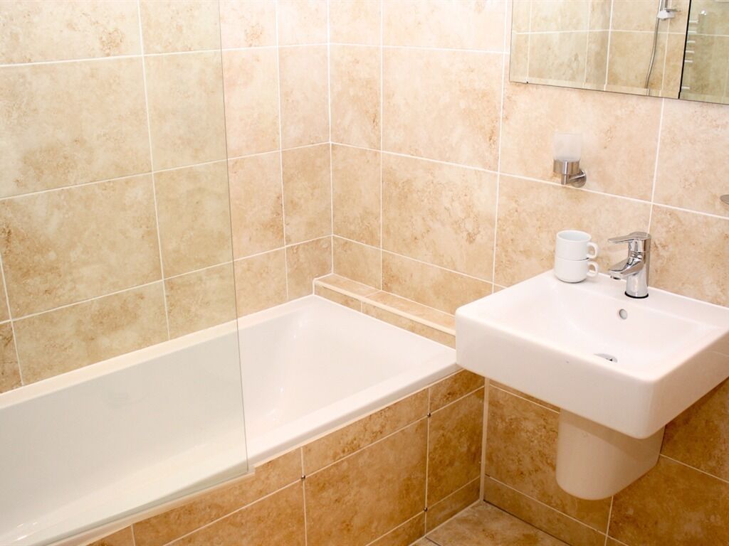 Ein Badezimmer mit Badewanne, Waschbecken und Spiegel.