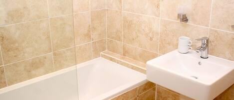 Ein Badezimmer mit Badewanne, Waschbecken und Spiegel.