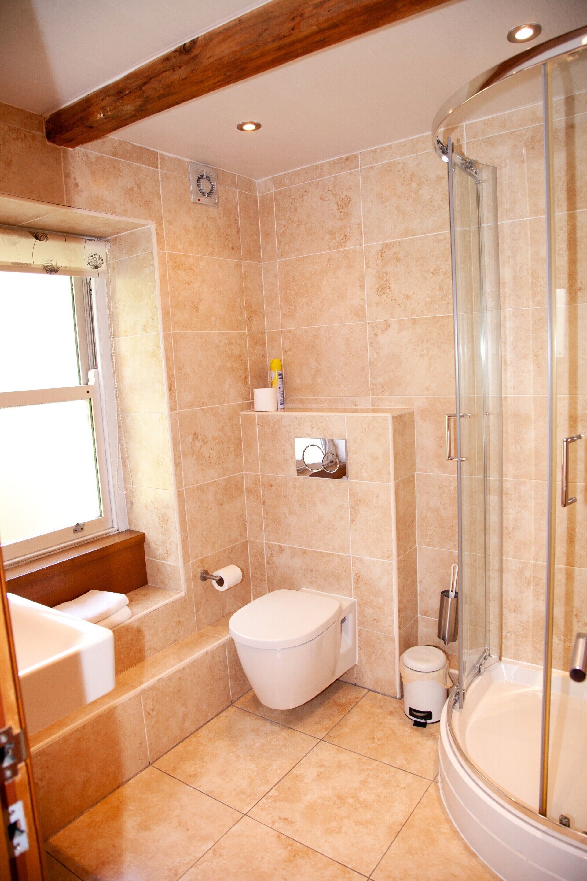 Baño con bañera, inodoro y cabina de ducha de vidrio.