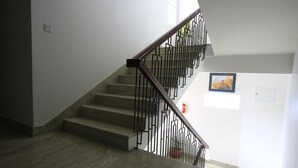 A staircase with a marble floor and black metal railings. - Rama Inn Boutique Home (Kathmandu)