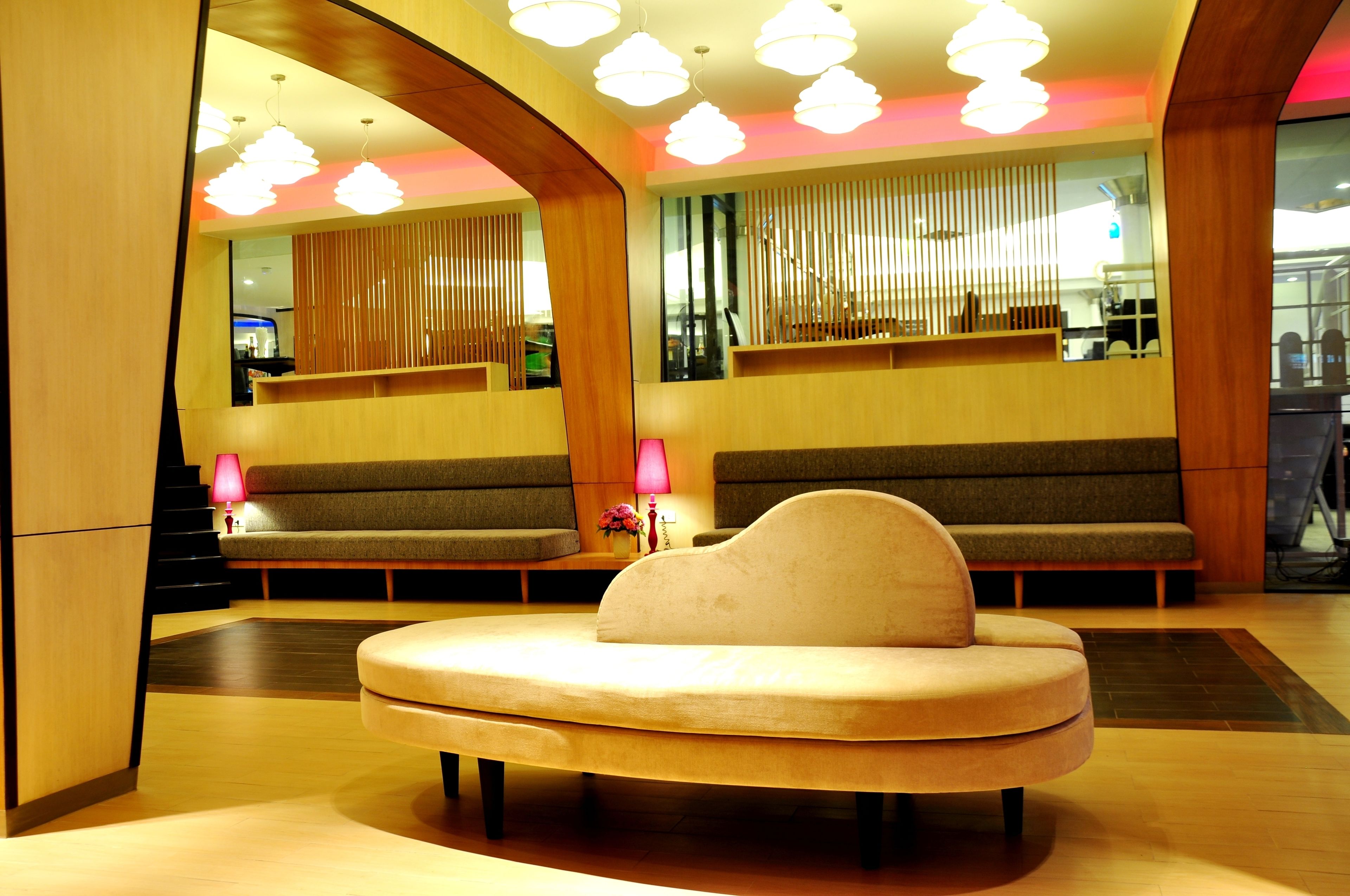A modern lobby with a sofa, a bench, and a reception desk.