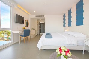 Una habitación de hotel moderna con cama, escritorio, silla y televisor.