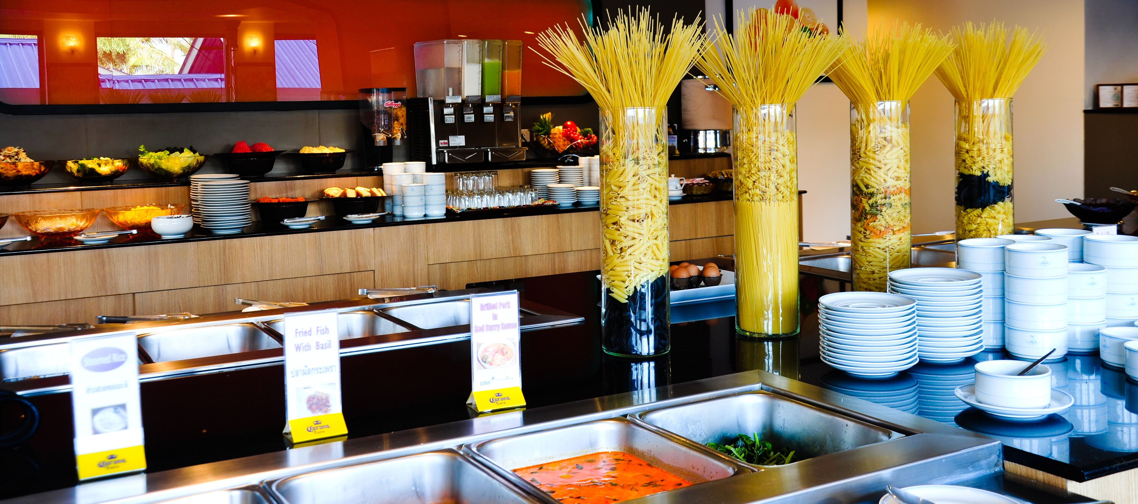 Un bufé con diversas opciones de comida, como pasta y ensaladas, y una estación de café.