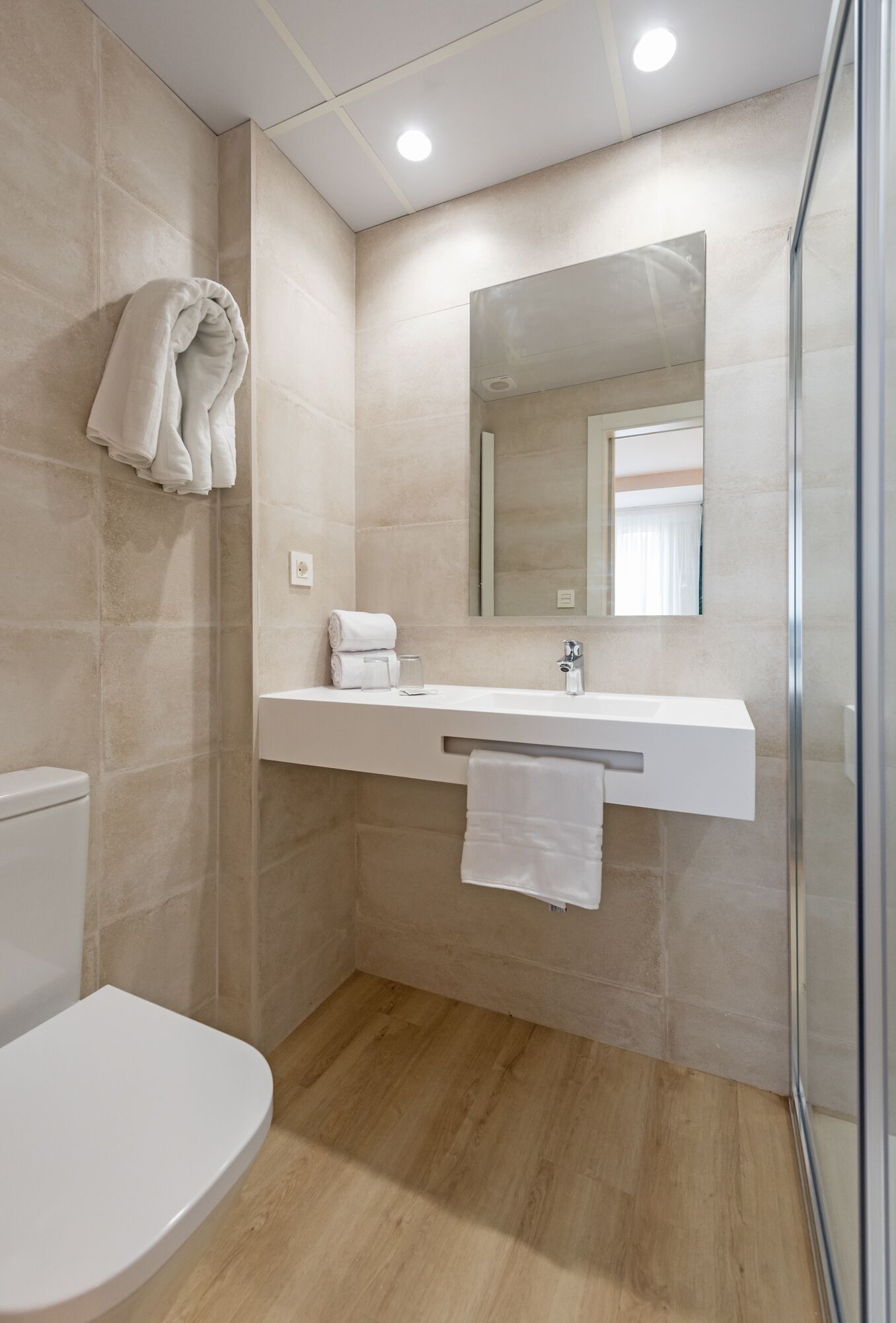 Une salle de bain moderne équipée de toilettes, d’un lavabo et d’un espace douche.