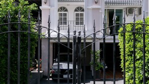 A gated entrance to a building with a white facade, arched windows, and a metal gate. - Villa Lamai - Wong Amat House Pattaya (Pattaya)