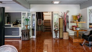 A spacious living area with a polished wooden floor, a staircase leading to an upper level, and a variety of decorative items including plants and artwork. - Villa Lamai - Wong Amat House Pattaya (Pattaya)