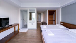 A hotel room with a TV, wooden bench, two beds, a sink, and a mirror. - Villa Lamai - Wong Amat House Pattaya (Pattaya)