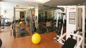 A gym with exercise equipment, a yellow exercise ball, and a mirror. - Keerati Homestay (Pattaya)