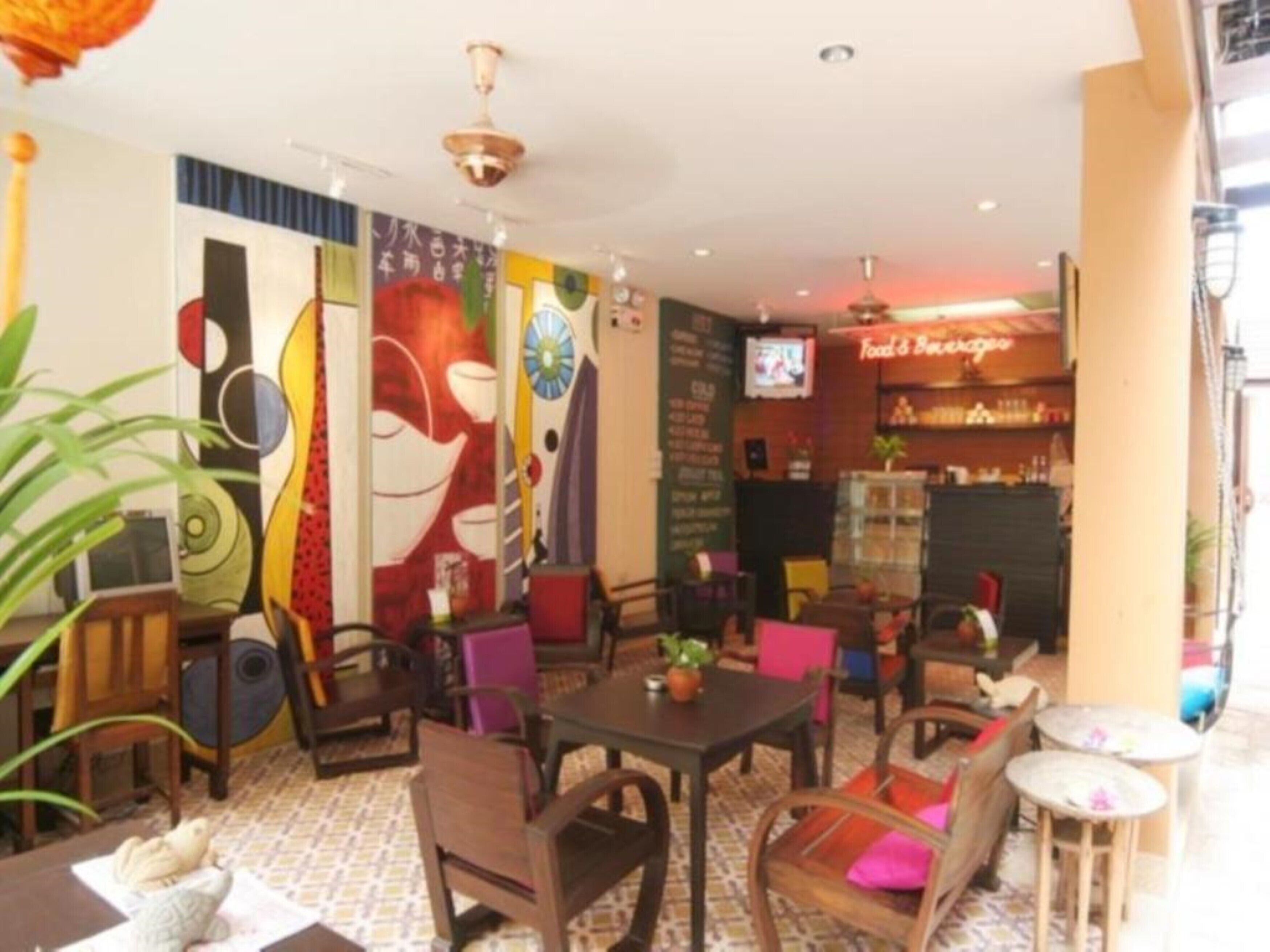 A restaurant with a variety of seating options, including tables and chairs, and a television mounted on the wall.