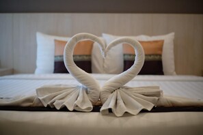 Ein Bett mit einer Herz-Handtuch-Arrangement.