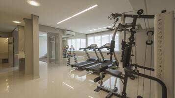 Uma academia moderna com esteiras, máquinas de peso e diversos equipamentos de exercício.