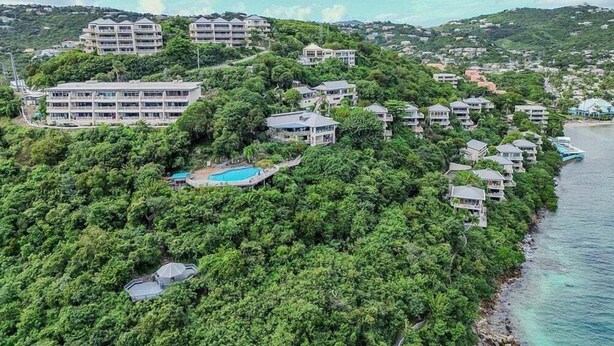 A coastal resort with multiple buildings, a swimming pool, and lush greenery. - Point Pleasant Resort (St. Thomas)