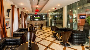 A lobby with leather seating, a bar area, and a reception desk. - Morning Side Suites (Lagos)