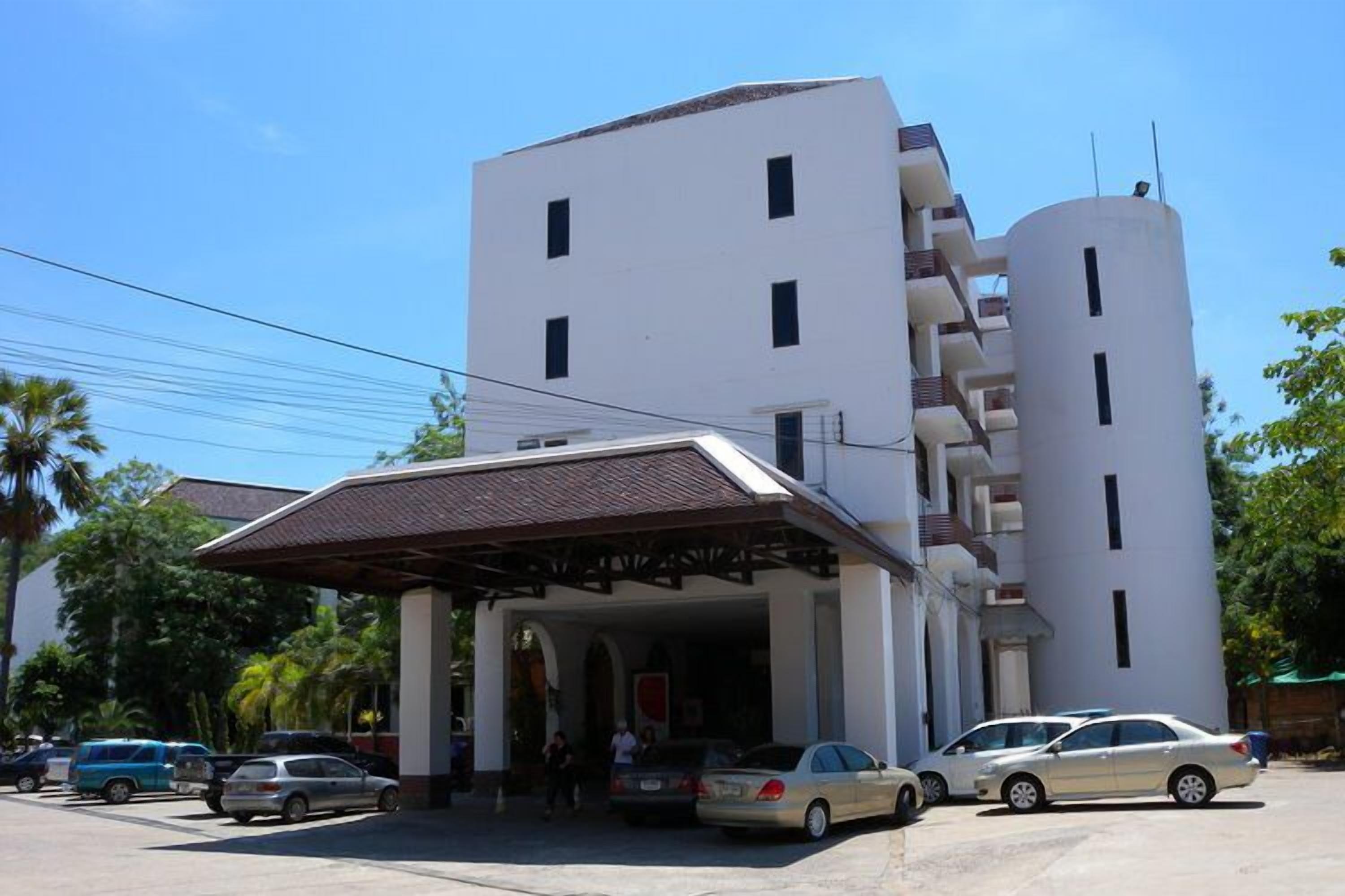 Un edificio moderno con entrada cubierta y zona de estacionamiento.