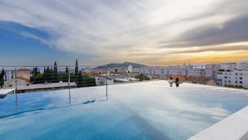 Una piscina al aire libre de temporada, sombrillas, tumbonas