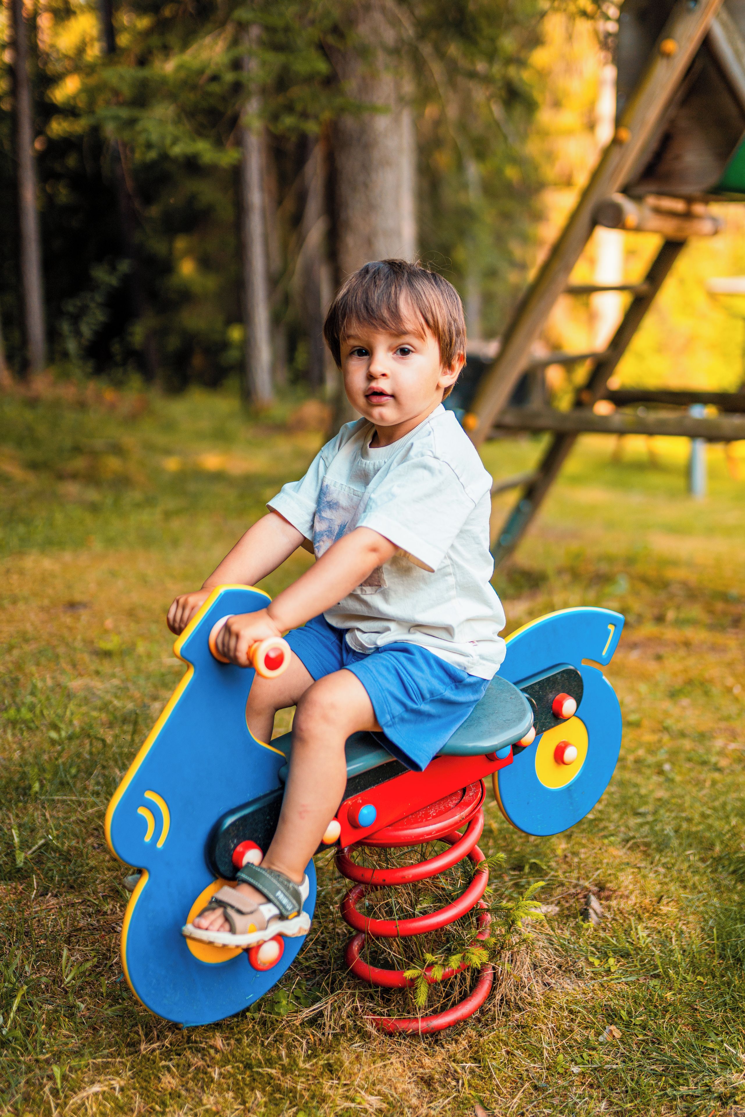 A child on a colorful outdoor ride-on toy.