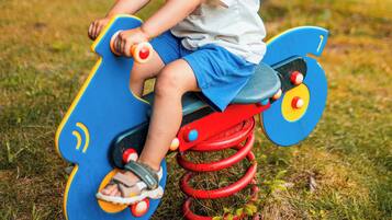 A child on a colorful outdoor ride-on toy.