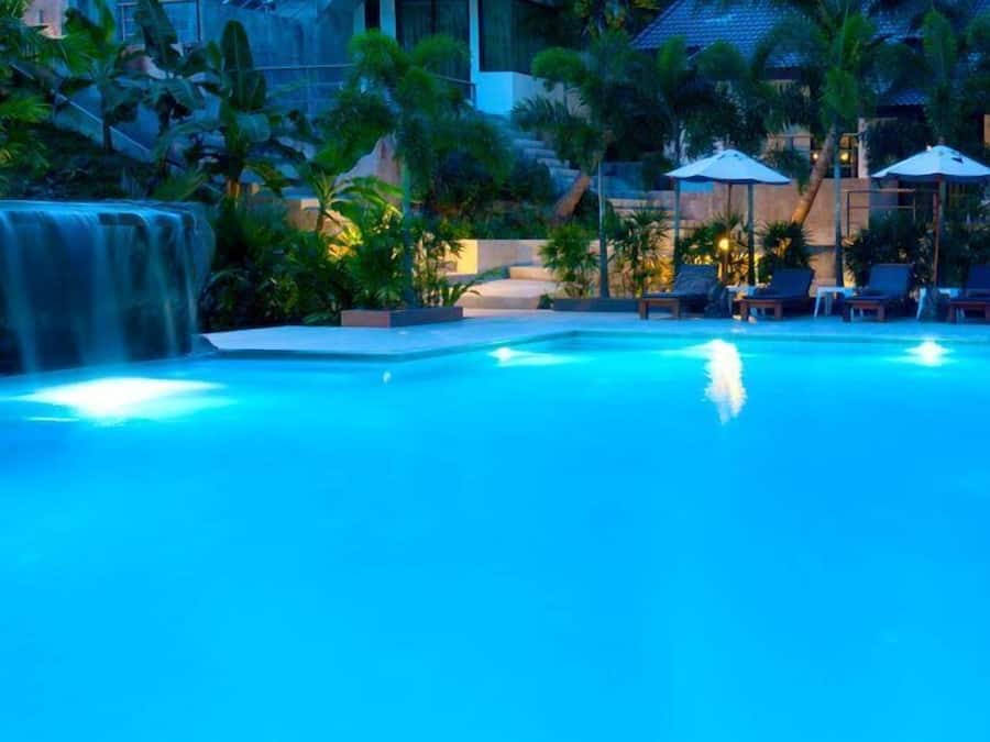 Una piscina al aire libre, sombrillas, tumbonas