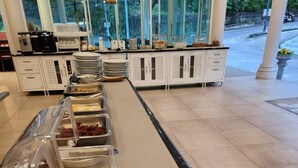 A buffet with various food items including fruits and snacks. - P.S Hill Resort (Patong)