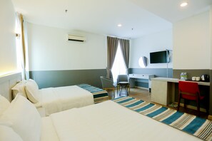 A hotel room with two beds, a desk, a chair, a TV, and an air conditioning unit. - The Explorer (Malacca City)