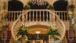 A grand lobby with a large chandelier, a marble staircase, and a central floral arrangement. - Mansión Merida Hotel Boutique - Restaurant  (Mérida)